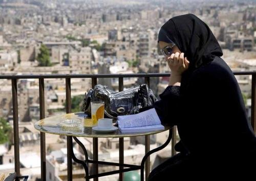 Young woman reading on a bar terrace. Aleppo, Syria (5/2009)